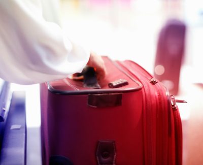 Suitcase being placed on airport check in belt