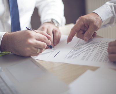 Two people signing a proposal