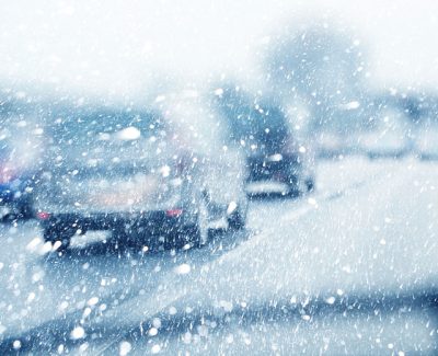 Blurry snowflake windscreen view of cars on the road in winter